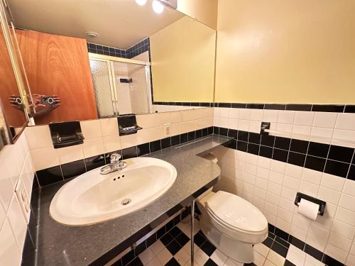 uma casa de banho com um lavatório, um WC e um espelho. em Cozy Philly Haven: Ideal Home em Filadélfia