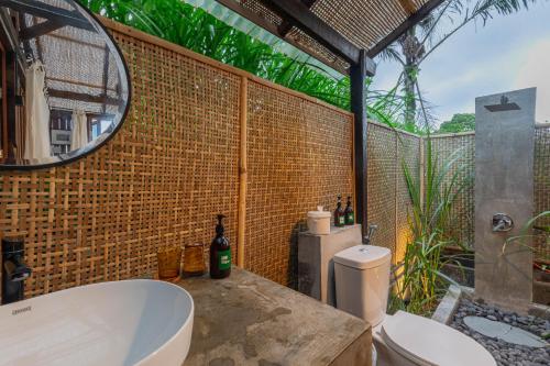 uma casa de banho com uma banheira e um espelho. em Calidas Hill em Kintamani