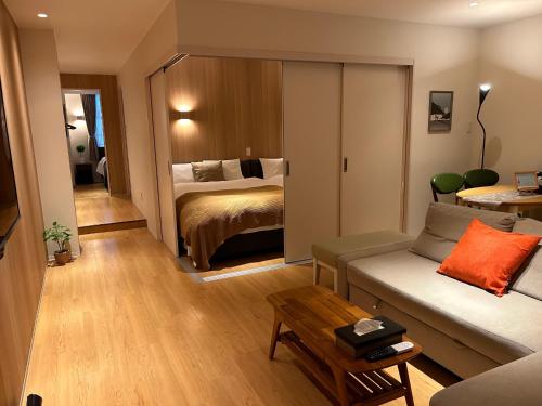 a living room with a couch and a bed at belle lune hotel hakata Suite Room 1 in Fukuoka