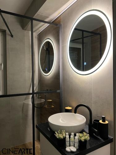 a bathroom with a sink and a mirror at CineArte Residence in Caransebeş
