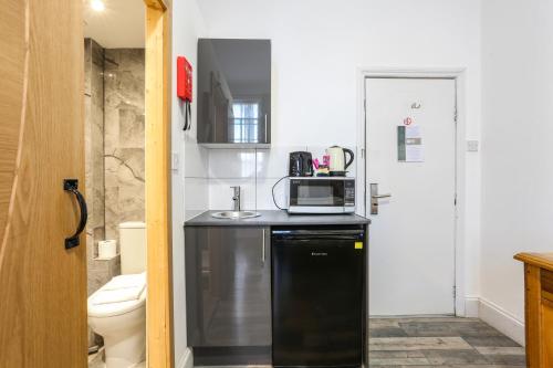 a small kitchen with a microwave on a counter at BeiRoom Hyde Park Apartments in London