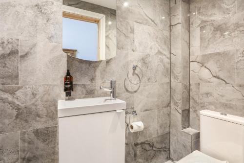 a bathroom with a toilet and a sink and a mirror at BeiRoom Hyde Park Apartments in London