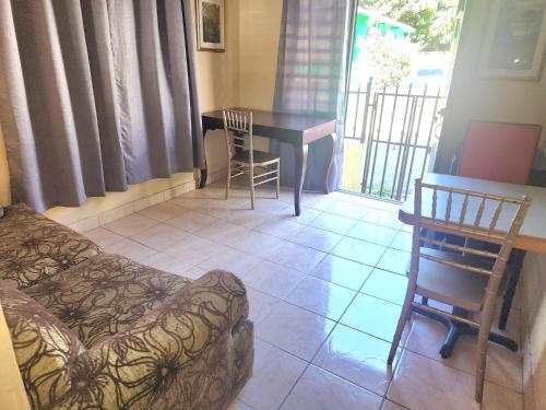 a living room with a couch and a table and chairs at Del Valle Central Casa near Trendy Calle Loiza- One bedroom with queen in San Juan