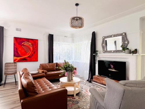 a living room with a couch and a fireplace at The Alice, Mittagong in Mittagong