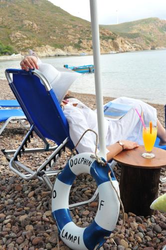 a person laying in a chair next to a table at Beachfront Lampis Dolphin 3 in Skala