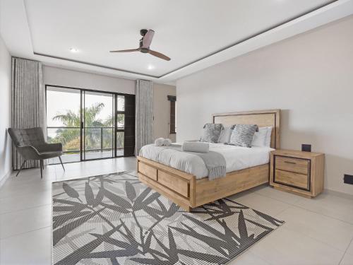 a bedroom with a bed and a desk and a chair at One on Chelsea by Host Agents in Durban