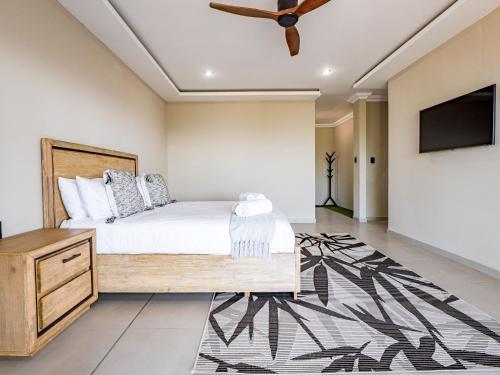 a bedroom with a bed and a ceiling fan at One on Chelsea by Host Agents in Durban