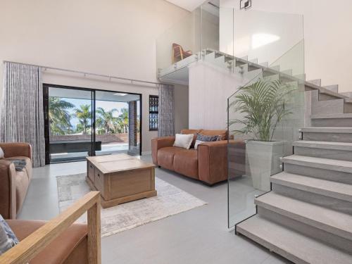 a living room with a staircase and a couch at One on Chelsea by Host Agents in Durban