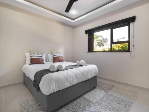 a bedroom with a large bed with a window at One on Chelsea by Host Agents in Durban