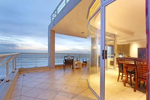 un balcon d'une maison avec une table et des chaises dans l'établissement Ocean View C602 by Host Agents, à Bloubergstrand