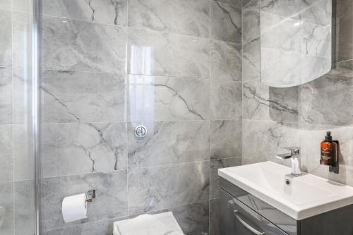 a bathroom with a white sink and a shower at BeiRoom Hyde Park Apartments in London