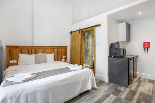 a bedroom with a large bed and a microwave at BeiRoom Hyde Park Apartments in London