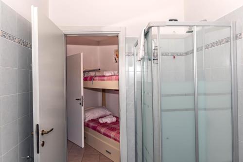 um pequeno quarto com um chuveiro e um beliche em La casa di Gabry in residence con piscina comune em Tavernola Bergamasca