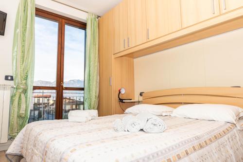 a bedroom with a bed with towels on it at La casa di Gabry in residence con piscina comune in Tavernola Bergamasca