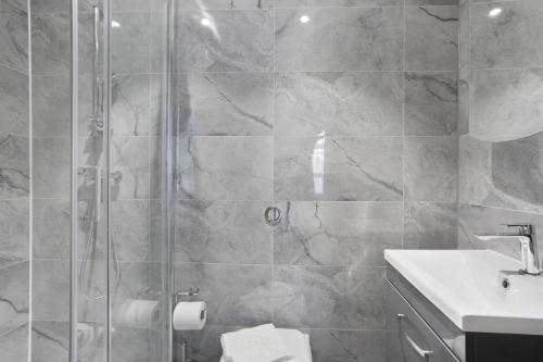 a bathroom with a shower and a toilet and a sink at BeiRoom Hyde Park Apartments in London