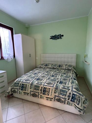 una camera da letto con un letto con un piumone di Bilocale con giardino a Marina di Grosseto