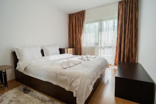 a bedroom with a large bed and a window at Renovated Gem Plumbuita Park in Bucharest