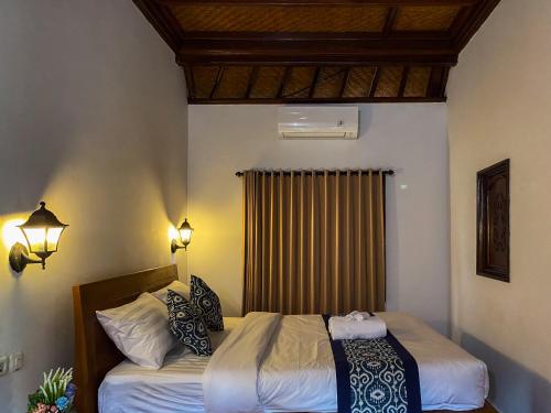 Habitación de hotel con cama y ventana en TM DARTA Homestay UBUD, en Ubud