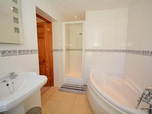 a white bathroom with a tub and a sink at 2 Bed in Looe LANDC in Duloe