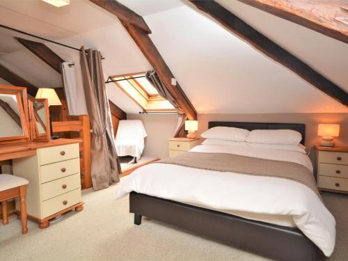 ein Schlafzimmer mit einem großen Bett im Dachgeschoss in der Unterkunft 3 Bed in Bude NPOAK in Poundstock