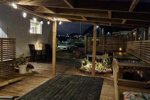 um deque exterior com uma mesa e comodidades para churrascos em Seaside house with stunning view 