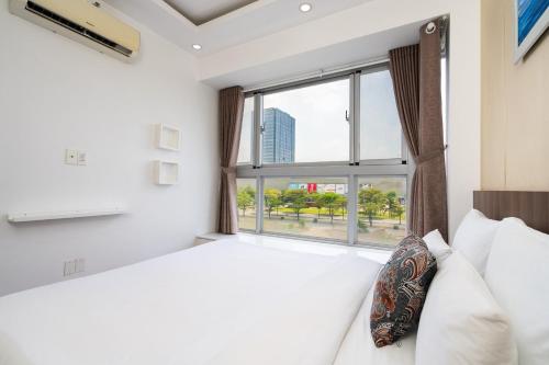 - une chambre avec un lit et une grande fenêtre dans l'établissement Lee's apartment at Scenicvalley, à Hô-Chi-Minh-Ville