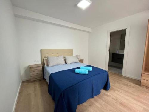 a bedroom with a blue bed with a blue table at Carbo Home moderno, Algemesi Home in Algemesí