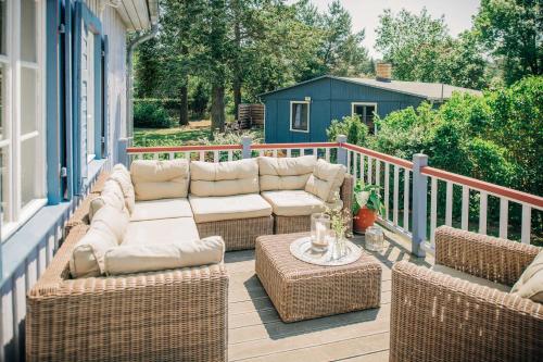 a patio with couches and a table on a porch at Pommernhaus Forsthaus Rieth am See, Sauna, Kamin, Ruderboot in Rieth