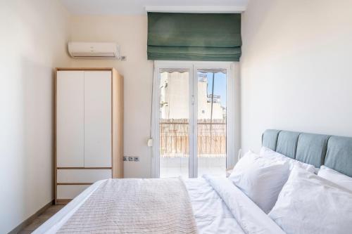 una camera bianca con un letto e una finestra di City Oasis: Newly Renovated 2Br Apt in City Center ad Atene