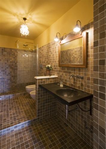 a bathroom with a sink and a toilet and a mirror at Country House Il Sassòne in Camerano