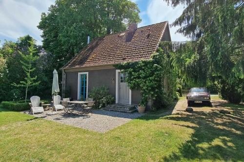 a small house with a table and chairs in a yard at Pommernhaus Josephinenhof, Sauna, Kamin, Ruderboot in Christianshof