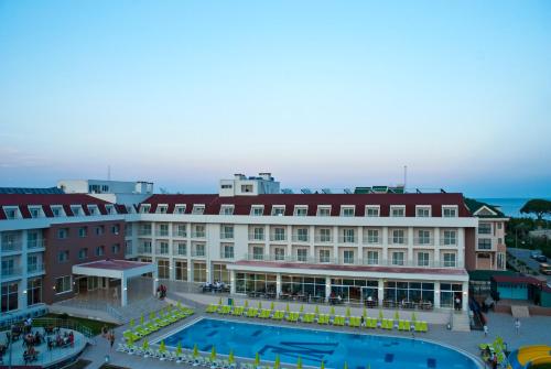 een groot gebouw met een zwembad ervoor bij white lilyum hotel in Antalya