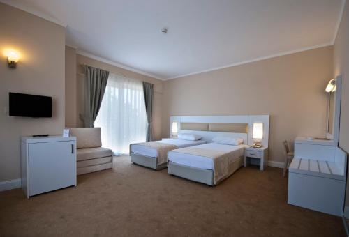 a hotel room with two beds and a television at white lilyum hotel in Antalya