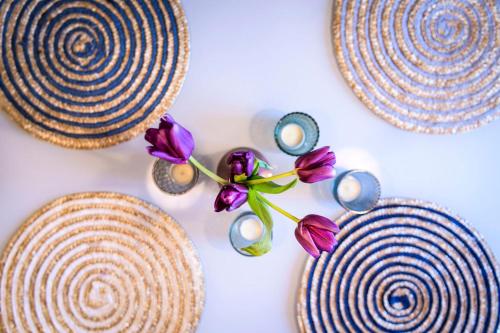 a group of three plates with purple flowers on a table at Pommernhaus mit Seeblick, Sauna, Kamin, Ruderboot in Rieth
