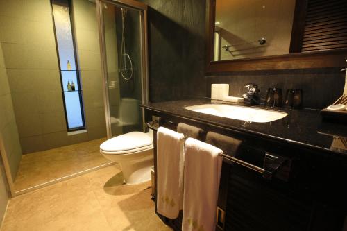 a bathroom with a sink and a toilet and a mirror at Niramaya Villa & Wellness in Ko Yao Noi