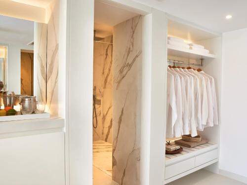a walk in closet with a marble wall at Grecotel LUXME White in Adelianos Kampos