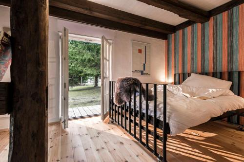 een slaapkamer met een bed en een glazen schuifdeur bij Pommernhaus Vorsee am Kiefernwald in Ahlbeck