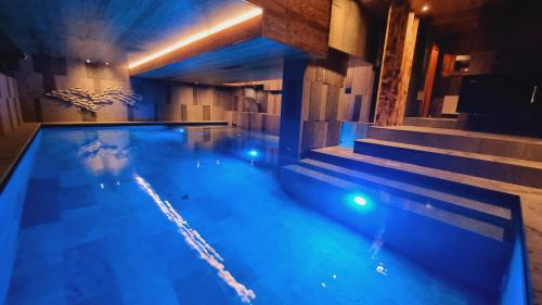 a swimming pool with blue lighting in a building at Penzion Zvonička in Pec pod Sněžkou