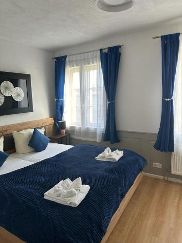 a bedroom with a blue bed with towels on it at Hotel Zum Goldenen Anker in Bamberg