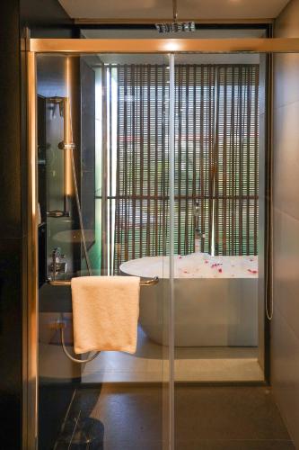 a bathroom with a bath tub and a shower at Radisson Resort and Spa Lonavala in Lonavala