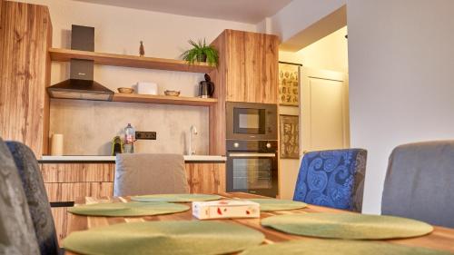 a dining room table with chairs and a kitchen at Family TreeZ Premium Apartments in Poiana Brasov