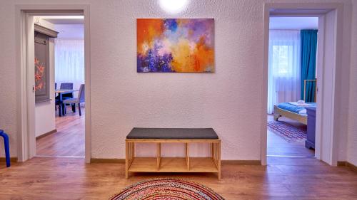 a living room with a table and a painting on the wall at Family TreeZ Premium Apartments in Poiana Brasov