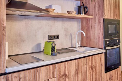 a kitchen with a sink and a microwave at Family TreeZ Premium Apartments in Poiana Brasov