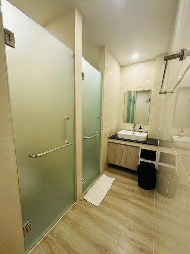 a bathroom with a sink and a glass shower door at 22 Twenty Two Chiang Mai in Chiang Mai