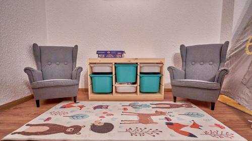 a room with two chairs and a table and a rug at Family TreeZ Premium Apartments in Poiana Brasov