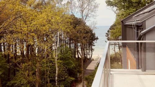 a view of the ocean from the balcony of a house at Dwie Sosny z sauną, Sun & Snow in Ustronie Morskie