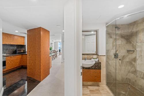 Un baño con lavabo y ducha de cristal. en Zanzibar 505, en Mooloolaba