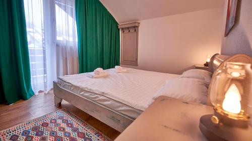 a bedroom with a bed and a green curtain at Family TreeZ Premium Apartments in Poiana Brasov