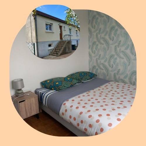 - une chambre avec un lit et un miroir rond dans l'établissement Les Cyclamens, à Cosne Cours sur Loire