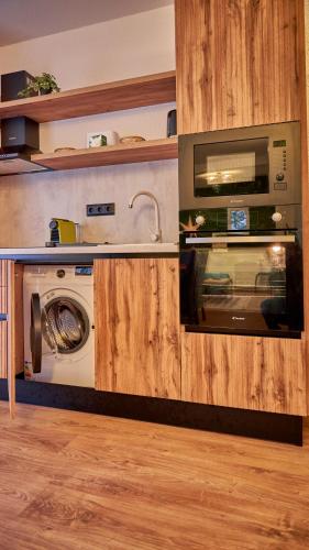 a kitchen with a microwave and a washing machine at Family TreeZ Premium Apartments in Poiana Brasov